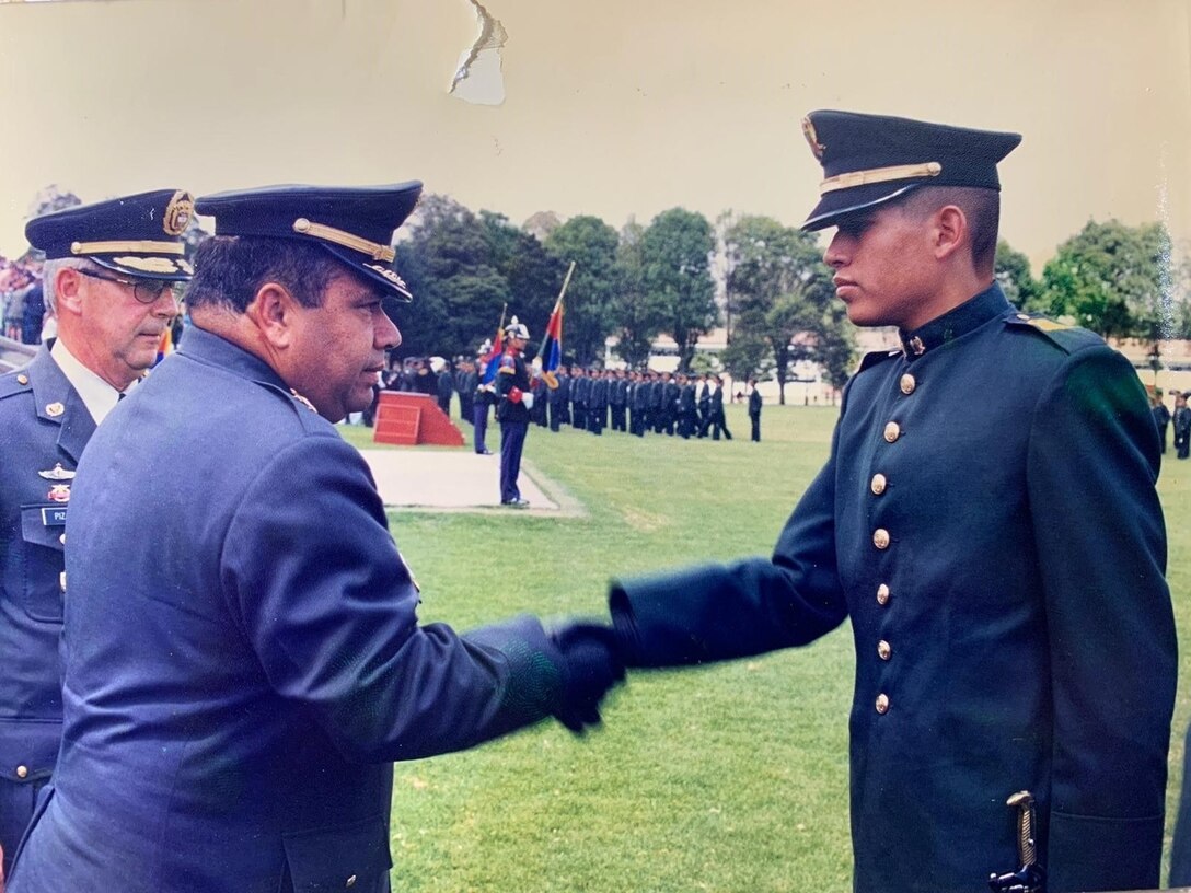 2nd Lt. Mauricio Garcia shakes hands with the school commander during graduation from a Colombian military officer school in Bogota, Colombia.