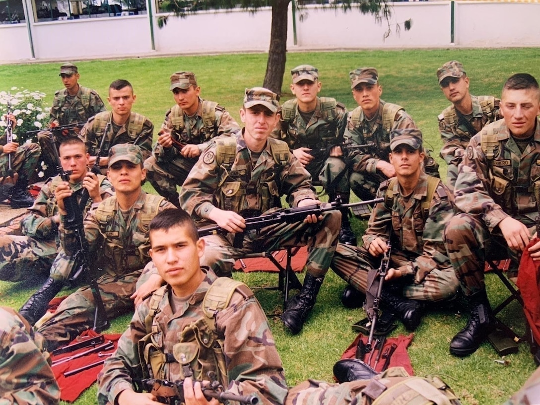 Cadet Mauricio Garcia, without hat in foreground, and fellow classmates, pose for a photo during a field training exercise at the military officer school in Bogota, Colombia.