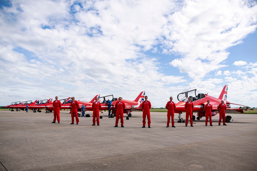 9 Pilots from the Royal Air Force aerobatic team, known as the Red Arrows, pose for a photo on the flightline at RAF Fairford, England, June 4, 2021. The Red Arrows landed at Fairford to refuel in preparation for the Midlands Air Festival. The pilots and crew members were able to integrate and meet with Airmen from the 501st Combat Support Wing. (U.S. Air Force photo by Senior Airman Eugene Oliver)