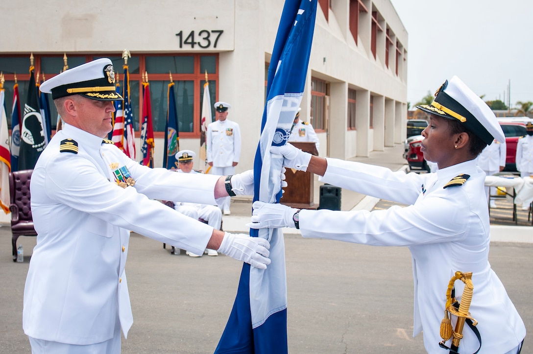 Cmdr. Jonathan Nieman, commanding officer of U.S. Naval Mobile Construction Battalion (NMCB) 3, passes the battalion colors.