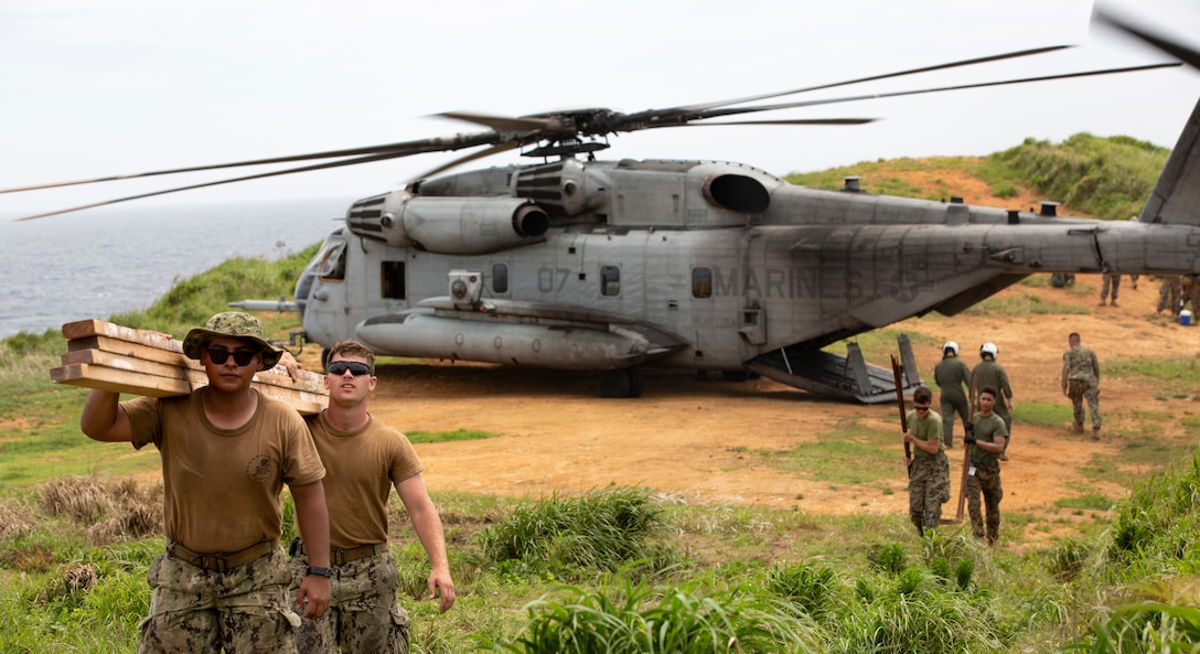 A CH-53E Super Stallion aircraft with Marine Heavy Helicopter Squadron 462 , airlifts Civil Engineering Support Equipment (CESE) and materials for a simulated Expeditionary Advanced Base onto W-174 Joint Okinawa Training Range Complex, an uninhabited island off the coast of Okinawa, Japan, in support of Naval Mobile Construction Battalion (NMCB) 4, as part of joint exercise Poseidon's Watchtower.