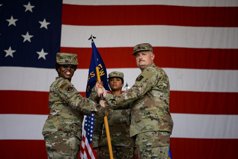 Two commanders pose for a photo during a ceremony.