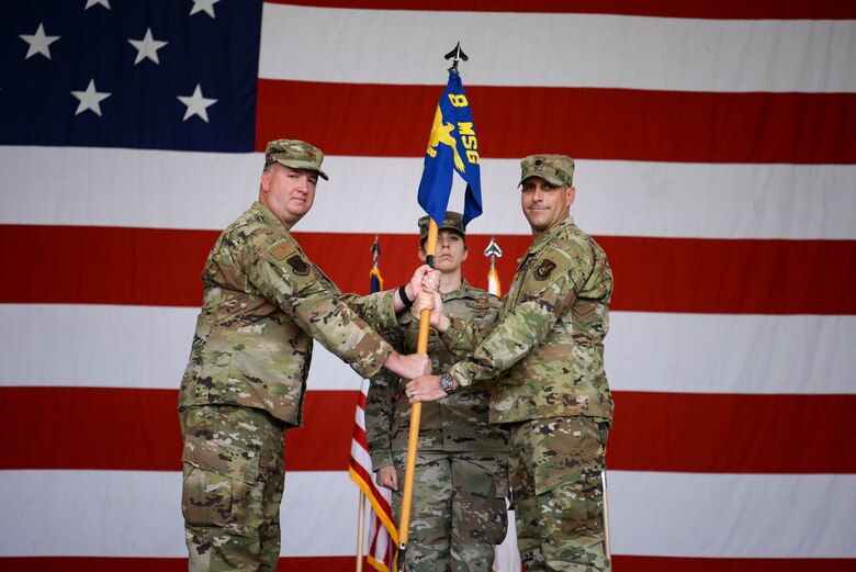 Two commanders pose for a photo during a ceremony.