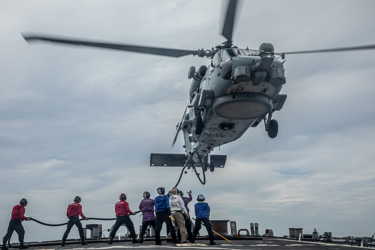 Sailors aboard Arleigh Burke-class guided-missile destroyer USS Curtis Wilbur (DDG 54) refuel a MH-60R Sea Hawk assigned to the Royal Australian Navy Anzac-class frigate HMAS Ballarat (FFH 155) on the flight deck. Curtis Wilbur is assigned to Commander, Task Force 71/Destroyer Squadron (DESRON) 15, the Navy’s largest forward-deployed DESRON and U.S. 7th Fleet’s principal surface force.