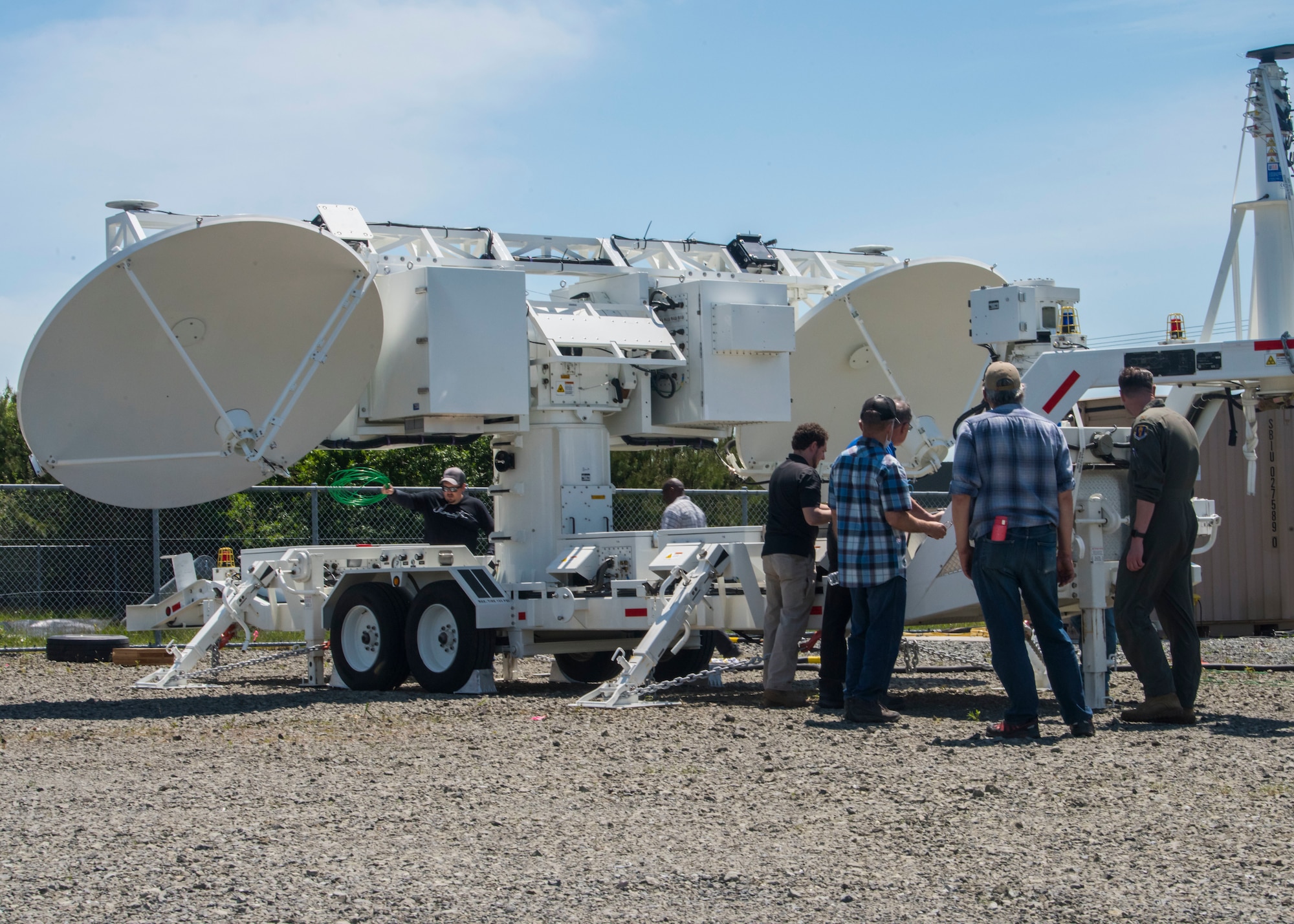 A group of men surround and provide maintenance on a Joint Threat Emitter.