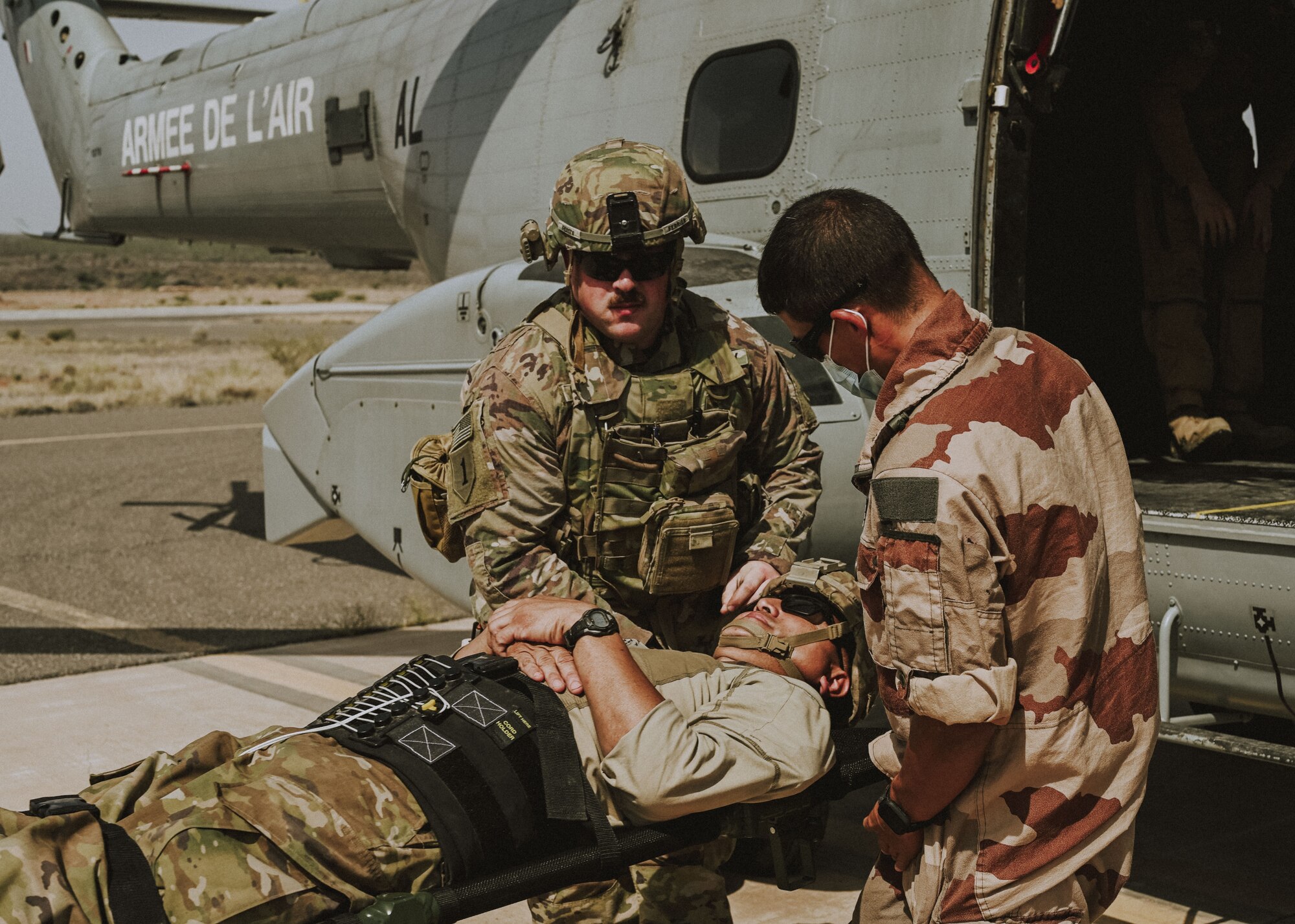 A soldier from Task Force Iron Gray and a French Air Force member load a simulated injured service member onto a French aircraft in support of the medical evacuation exercise May 31, 2021, at Chabelley Airfield, Djibouti. The French Air Force took initiative to provide their aircraft in order to transfer the simulated injured patients from Chabelley Airfield to Camp Lemonnier in Djibouti. (U. S. Air Force photo by Airman 1st Class Jan K. Valle)