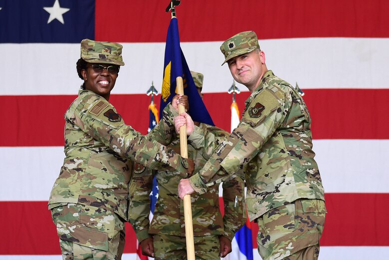Two commanders pose for a photo during a ceremony.