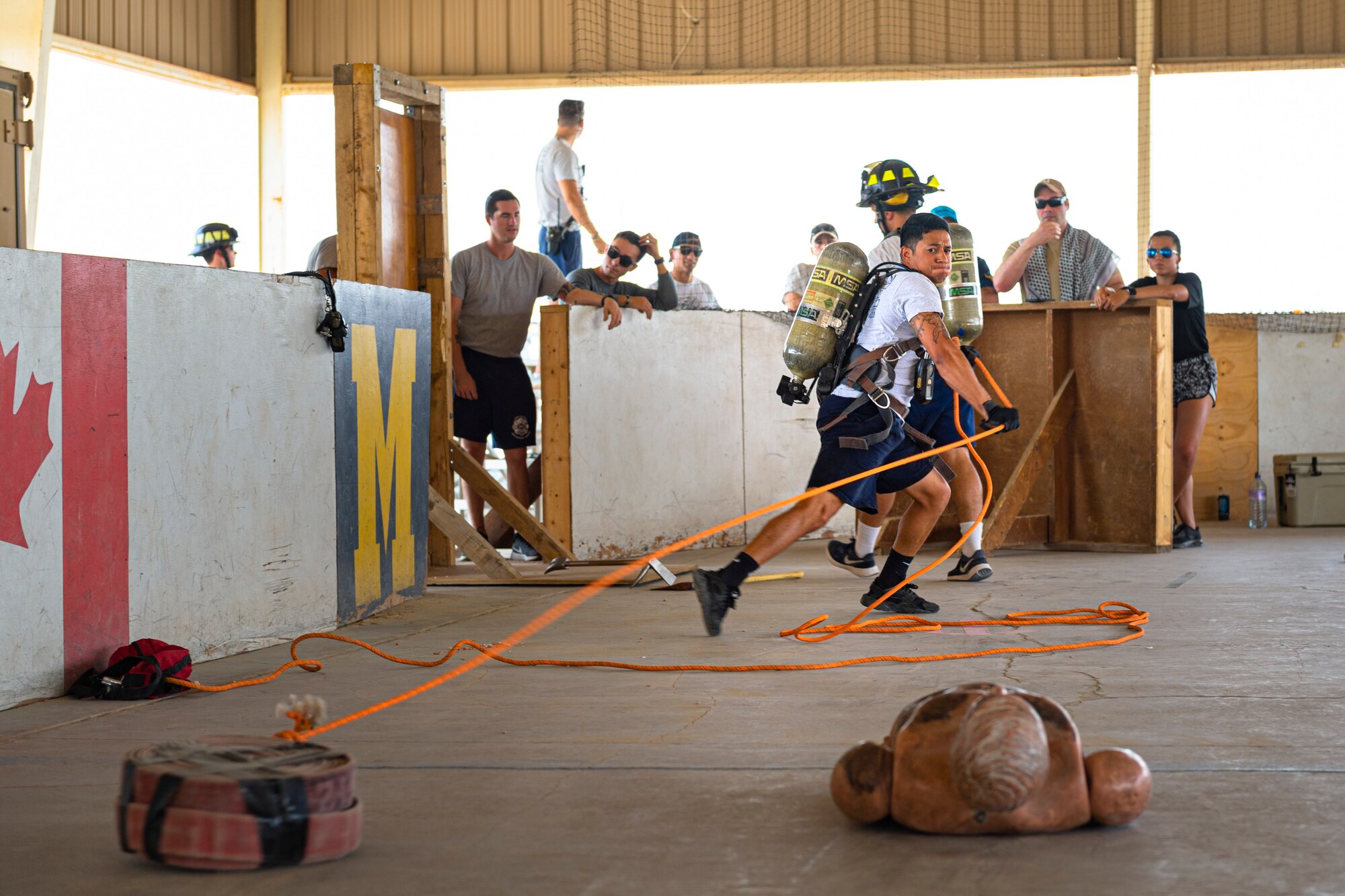 A photo of an Airman pulling a fire hose