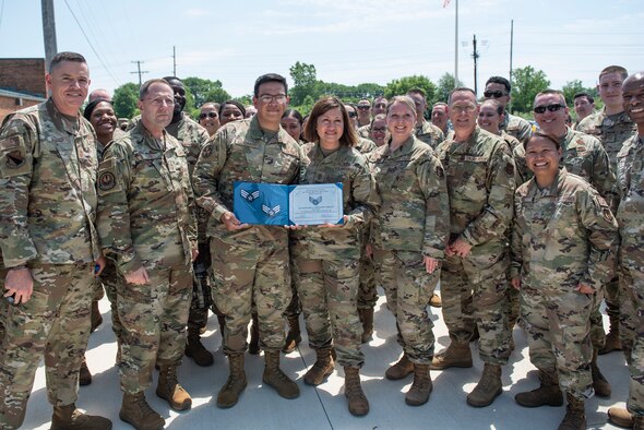 Chief Master Sergeant of the Air Force JoAnne S. Bass and other Airmen from around the base pose for a photo with Airman 1st Class Leonardo Castillo Coronado, a medical technician with the 88th Medical Group, after he found out that he has been selected for promotion to Senior Airman Below the Zone during a Total Force Barbecue as part of her multiday visit to Wright-Patterson Air Force Base, Ohio, June 4, 2021. A three-day base tour brought Bass to several units within the 88th Air Base Wing, Air Force Materiel Command, Air Force Life Cycle Management Center and Air Force Research Laboratory. (U.S. Air Force photo by Wesley Farnsworth)