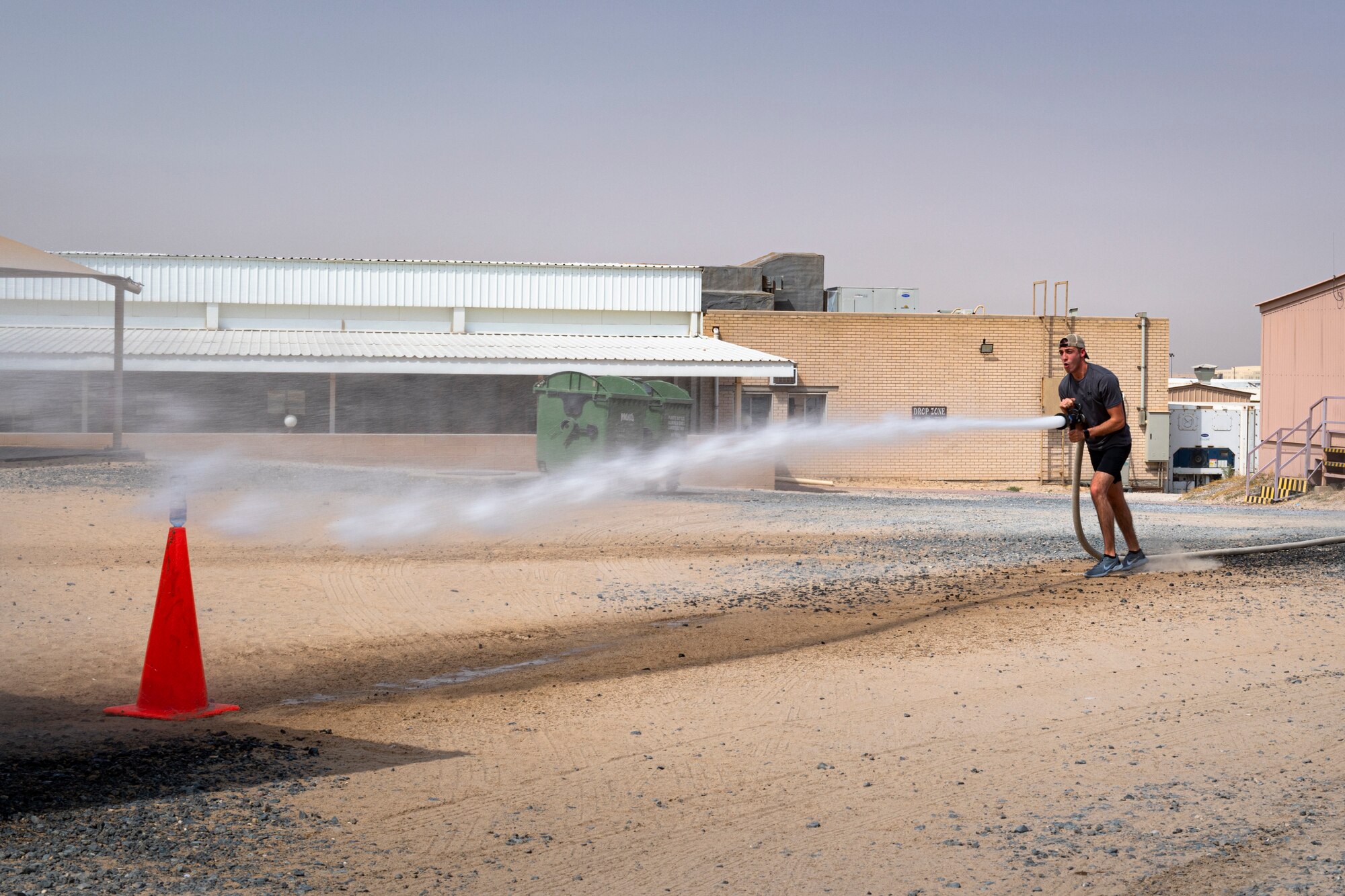 A photo of an Airman using a fire hose