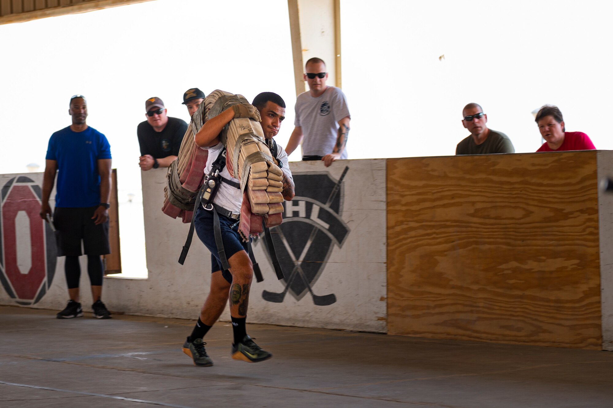 A photo of an Airman carrying a fire hose