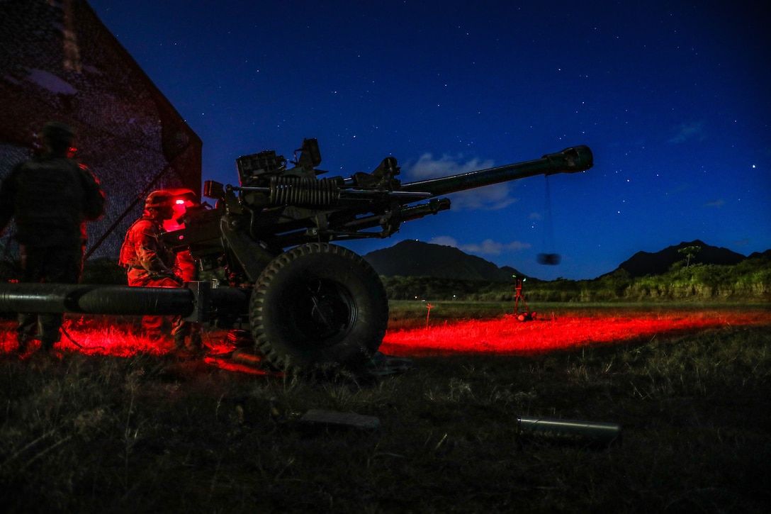 Soldiers train to fire a Howitzer at night.