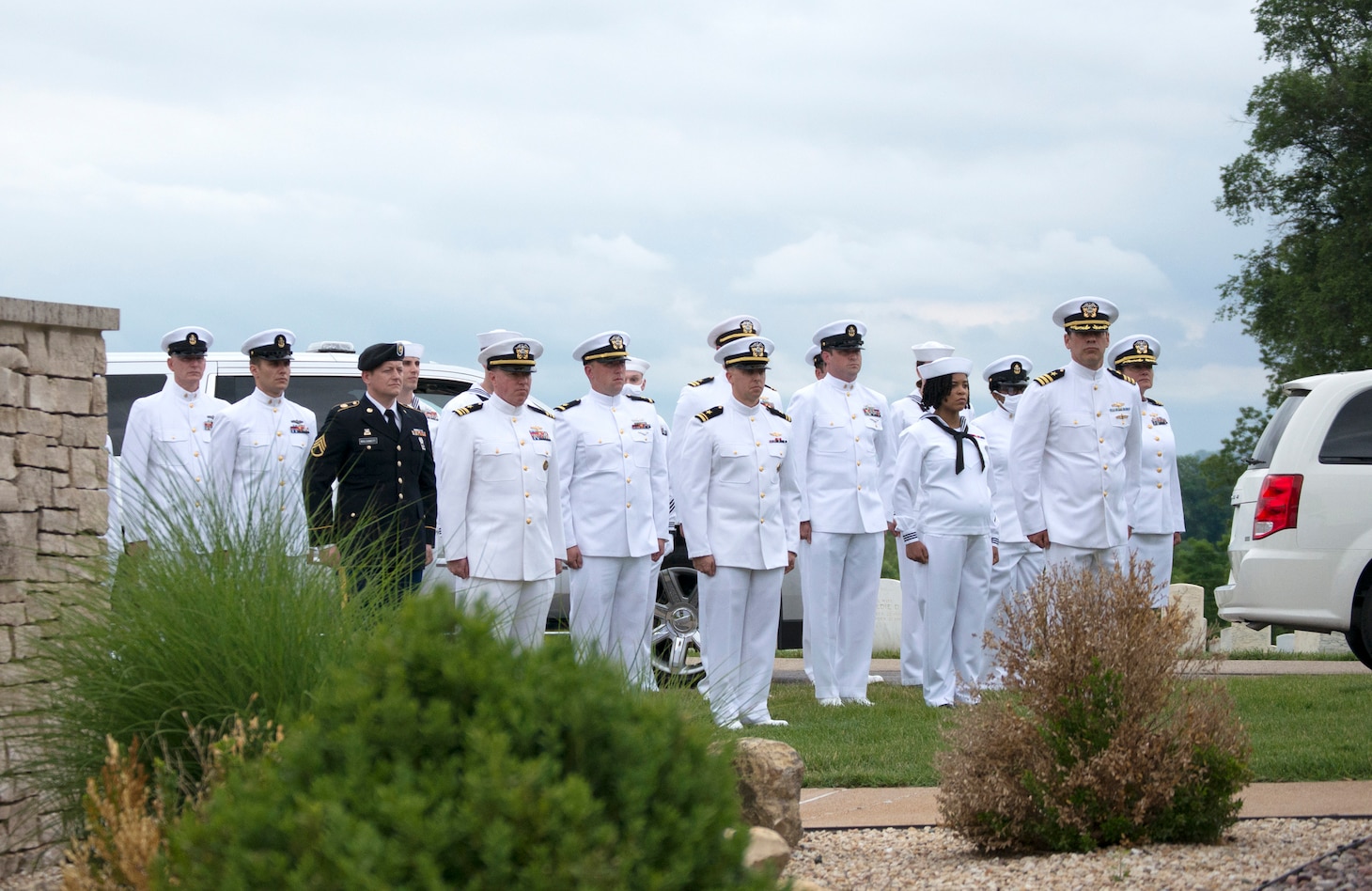 Members of Navy Joint Intelligence Center Detachment 0382, a reserve unit from Navy Operational Support Center St. Louis, stand at attention to honor a fallen sailor at the graveside burial of Navy Mess Attendant 3rd Class Isaac Parker June 8, 2021 at Jefferson Barracks National Cemetery in St. Louis, MO. Parker was killed aboard the USS Oklahoma (BB-37) when it received up to eight torpedo hits and capsized in less than 12 minutes during the attack on Pearl Harbor, HI, December 7, 1941. He was reunited with his father, mother and six other relatives also buried at the cemetery, 79 years after his death following positive identification by the Defense POW/MIA Accounting Agency in 2020. (U.S. Navy photo by Petty Officer 2nd Class Jermain Geerhart)