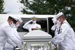 ST LOUIS. (June 8, 2021) – Rear Adm. Eric Peterson, Deputy Commander, Naval Medical Forces Atlantic, renders a final salute to Navy Mess Attendant 3rd Class Isaac Parker as pallbearers included local Navy reservists and staff from Navy Operational Support Center St. Louis, moves his casket into position over his gravesite at Jefferson Barracks National Cemetery in St. Louis, MO, June 8, 2021. Parker was killed aboard the USS Oklahoma (BB-37) when it received up to eight torpedo hits and capsized in less than 12 minutes during the attack on Pearl Harbor, HI, December 7, 1941. He was reunited with his father, mother and six other relatives buried at the cemetery, 79 years after his death following positive identification by the Defense POW/MIA Accounting Agency in 2020. (U.S. Navy photo by Petty Officer 2nd Class Jermain Geerhart)