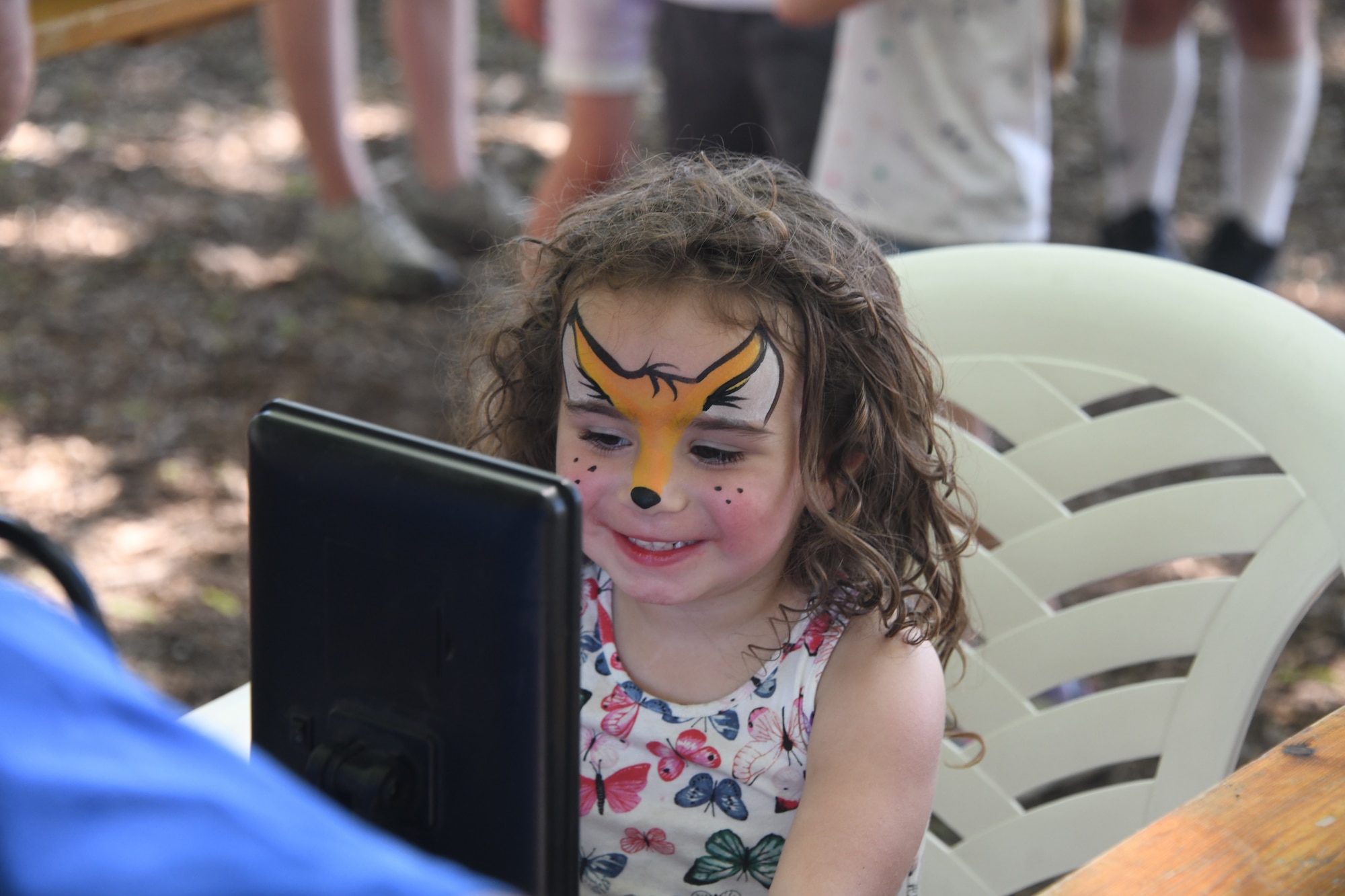 Amelia Strange, daughter of Tech. Sgt. Selina Strange smiles as she sees her face painted as a fox for the first time at the 2021 557th Weather Wing Picnic at the Bellevue Berry Farm in Bellevue, Nebraska on June 4, 2021.