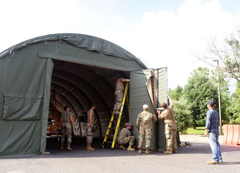 Members of 87th Civil Engineering Squadron are tearing down a Californian tent used for outdoor COVID-19 testing outside the 87th Medical Group facility, June 10th, 2021, on Joint Base McGuire-Dix-Lakehurst, N.J. Within the 14-month period, the 87th CES assembled and maintained  an outdoor 87th MDG COVID-19 testing site, which consisted of two Californian and Alaskan tents, equipped with a power generator, electricity, lighting, HVAC, porta-potties, guard facilities, and traffic control. This testing site was called the Military Treatment Facility (MTF) Tent City. (U.S. Air Force photo by Daniel Barney)