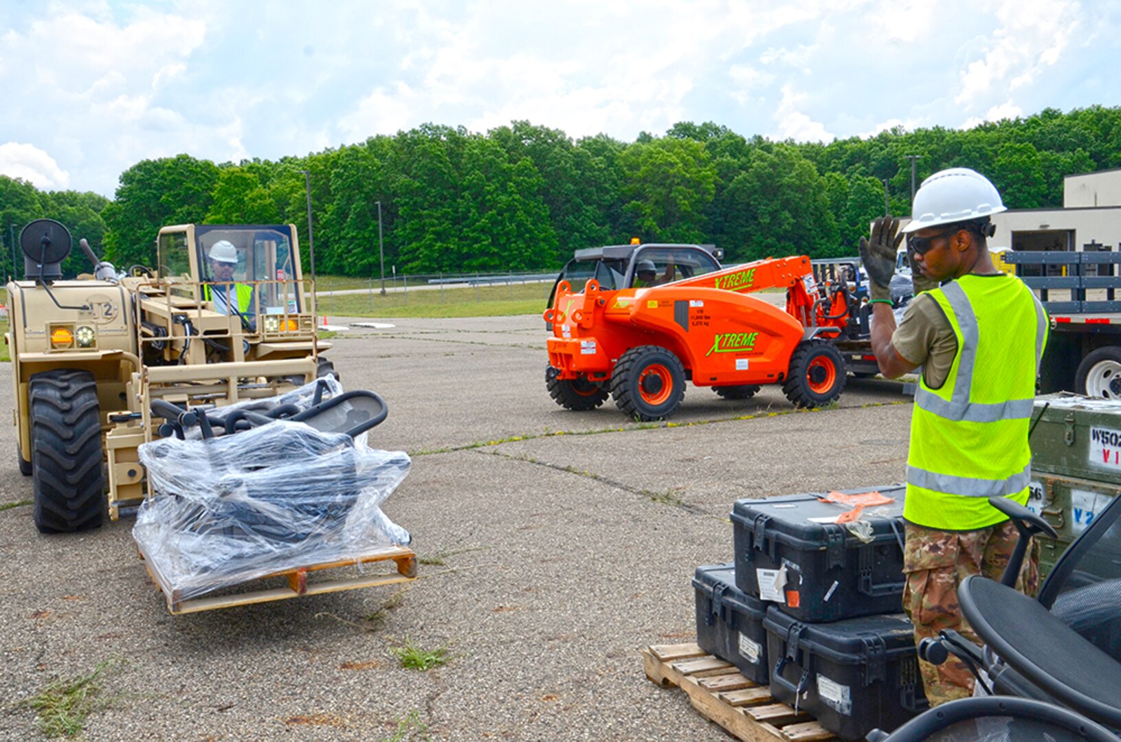 A man directs another man operating a forklift.