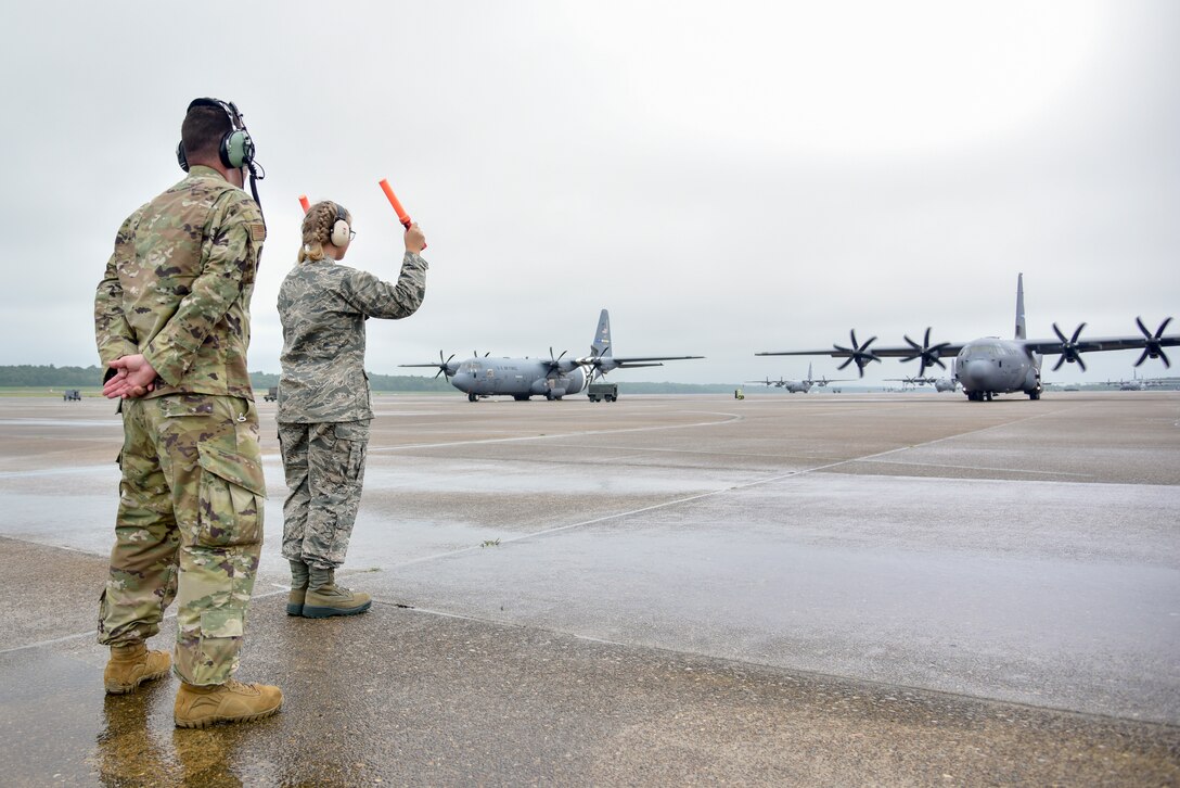 Junior ROTC cadet marshals aircraft.