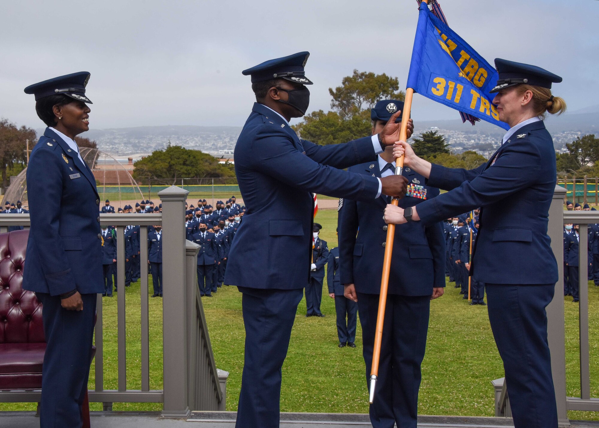 U.S. Air Force Lt. Col. William Taylor, incoming 311th Training Squadron commander, receives the guidon, a symbol of command, from Col. Stephanie Kelley, assistant commandant and commander of the 517th Training Group at the change of command ceremony at Soldier Field, Presidio of Monterey, California, June 4, 2021. Taylor comes to the Presidio of Monterey from the National Air and Space Intelligence Center, Ramstein Air Base, Germany. (Photo courtesy of Natela Cutter)