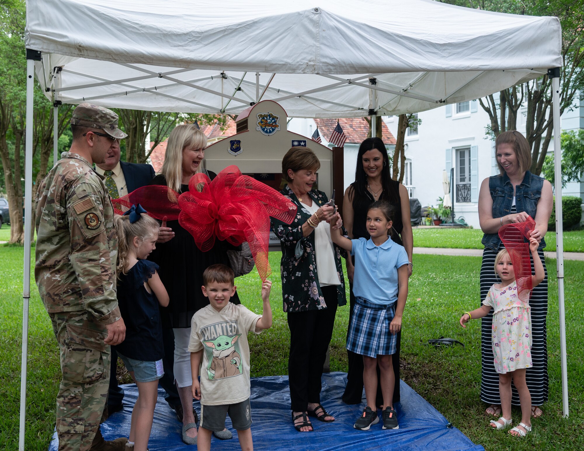 Nell Calloway, president of the Chennault Museum, cuts a ribbon to officially open the new community book exchange box at Barksdale Air Force Base, June 8, 2021. Calloway is the granddaughter of Lt. Gen. Claire Chennault, to whom the book exchange box is dedicated