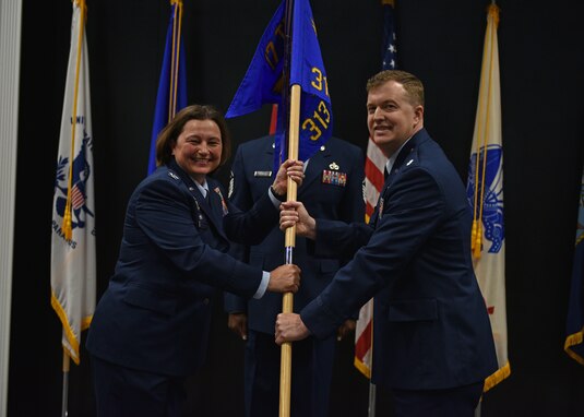 U.S. Air Force Col. Angelina Maguinness, 17th Training Group commander, passes the guidon to Lt. Col. Daniel Blackledge, incoming 313th Training Squadron commander, during the change of command ceremony at the Event Center on Goodfellow Air Force Base, Texas, June 11, 2021. Blackledge was previously the divison chief for the Joint Intelligence Operations Center at the U.S. Strategic Command in Nebraska. (U.S. Air Force photo by Senior Airman Ashley Thrash)