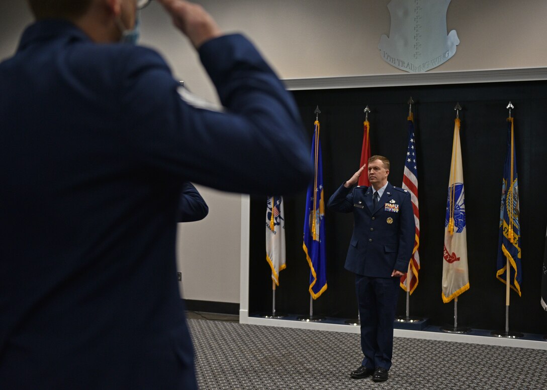 Members of the 313th Training Squadron salute U.S. Air Force Lt. Col. Daniel Blackledge, incoming 313th Training Squadron commander, during the change of command ceremony at the Event Center on Goodfellow Air Force Base, Texas, June 11, 2021. The salute represents the squadron welcoming their new commander. (U.S. Air Force photo by Senior Airman Ashley Thrash)