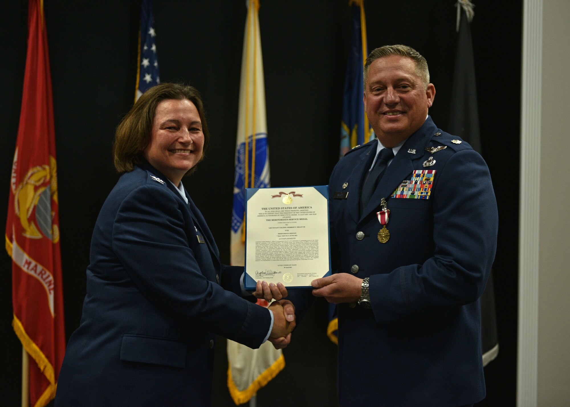 U.S. Air Force Col. Angelina Maguinness, 17th Training Group commander, presents Lt. Col. Herbert Millet III, 313th Training Squadron outgoing commander, the Meritorious Service Medal during the change of command ceremony at the Event Center on Goodfellow Air Force Base, Texas, June 11, 2021. Millet was decorated for his performance and dedication to the 313th TRS which led to the squadron winning the 2020 Air Education and Training Command Training Squadron of the Year. (U.S. Air Force photo by Senior Airman Ashley Thrash)