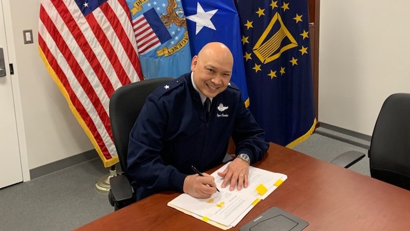 a U.S. Air Force general officer signs a paper