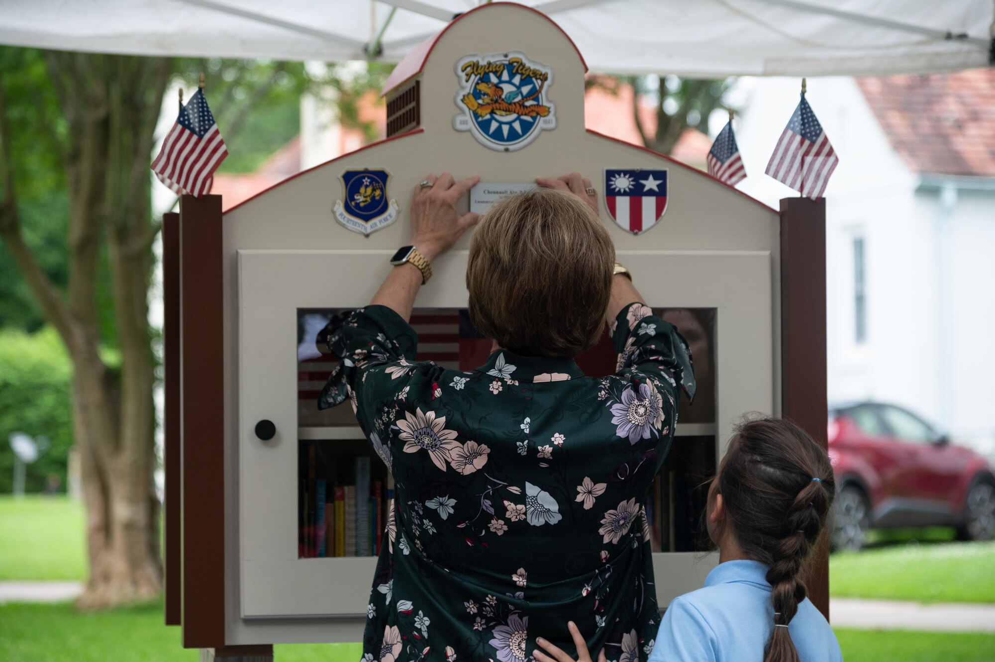 Nell Calloway, president of the Chennault Museum, adds a commemorative plaque to the new community book exchange box at Barksdale Air Force Base, June 8, 2021. Calloway is the granddaughter of Lt. Gen. Claire Chennault, to whom the book exchange box is dedicated.