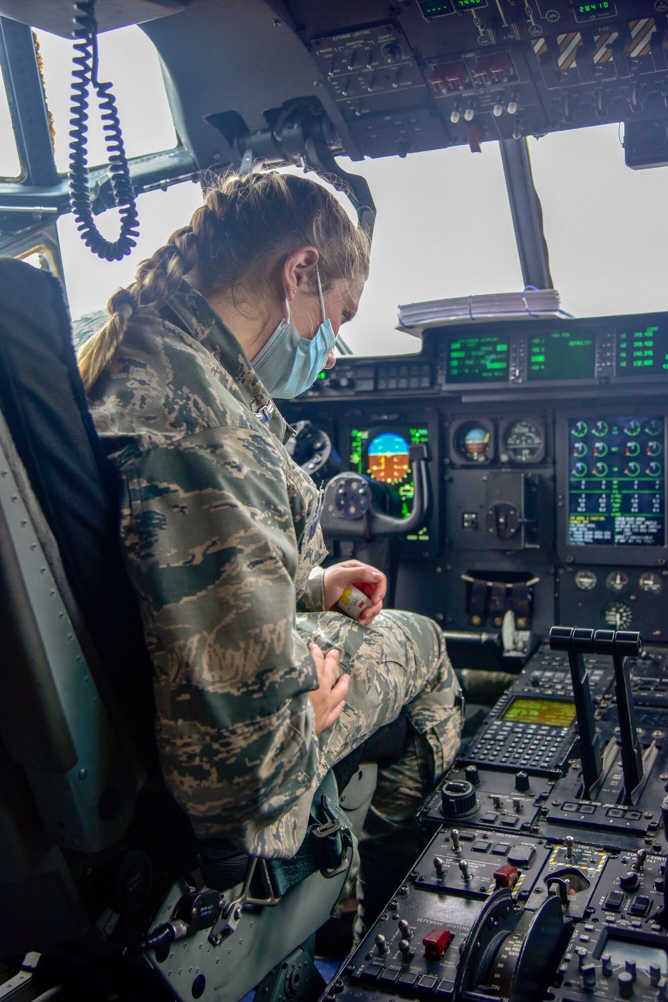 Junior ROTC cadet sits in the pilot seat of an aircraft.