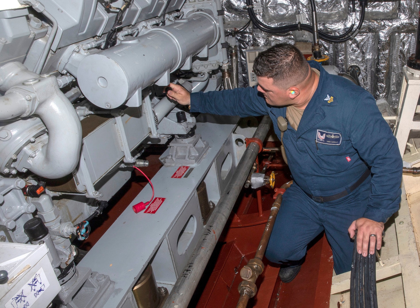 Engineman 1st Class Anier Carrillo checks the fitting of a 3D-printed valve aboard the Freedom-variant littoral combat ship USS Indianapolis (LCS 17) at Mayport Naval Station, Fla.