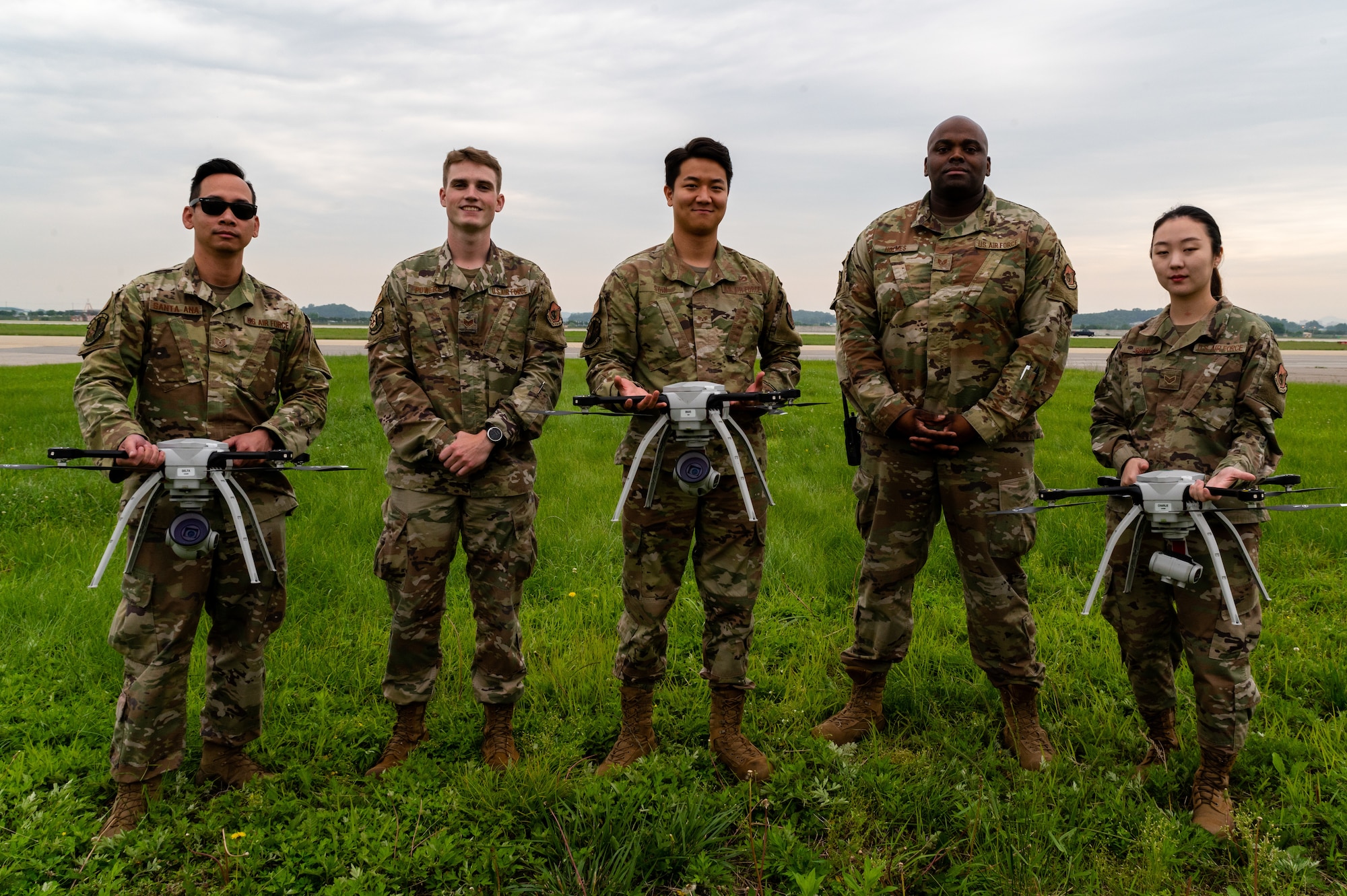 Small unmanned aircraft system operators from the 51st Civil Engineer Squadron, pose with their equipment at Osan Air Base, Republic of Korea, June 6, 2021. These operators conduct quarterly aerial assessments of the airfield, as part of the Rapid Airfield Damage Assessment System. (U.S. Air Force photo by Tech. Sgt. Nicholas Alder)