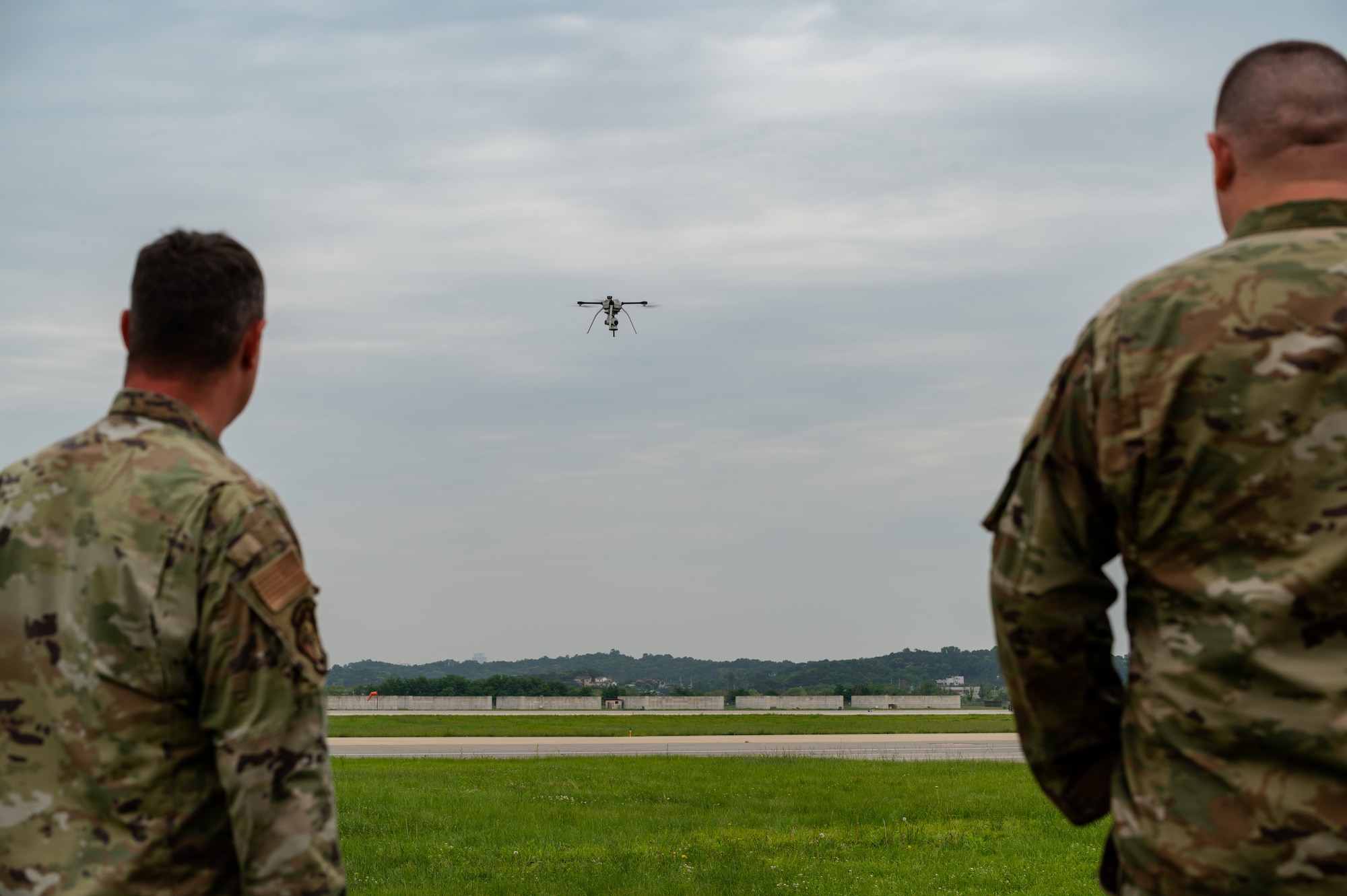 Tech. Sgt. Adam Crough, 51st Fighter Wing flight safety manager, left, and Tech. Sgt. Charles Smith, 51st Civil Engineer Squadron contracting officer representative, observe the landing of a small unmanned aircraft system at Osan Air Base, Republic of Korea, June 6, 2021. Members of the 51st Civil Engineer Squadron perform quarterly flights to maintain their SUAS operator proficiency. (U.S. Air Force photo by Tech. Sgt. Nicholas Alder)