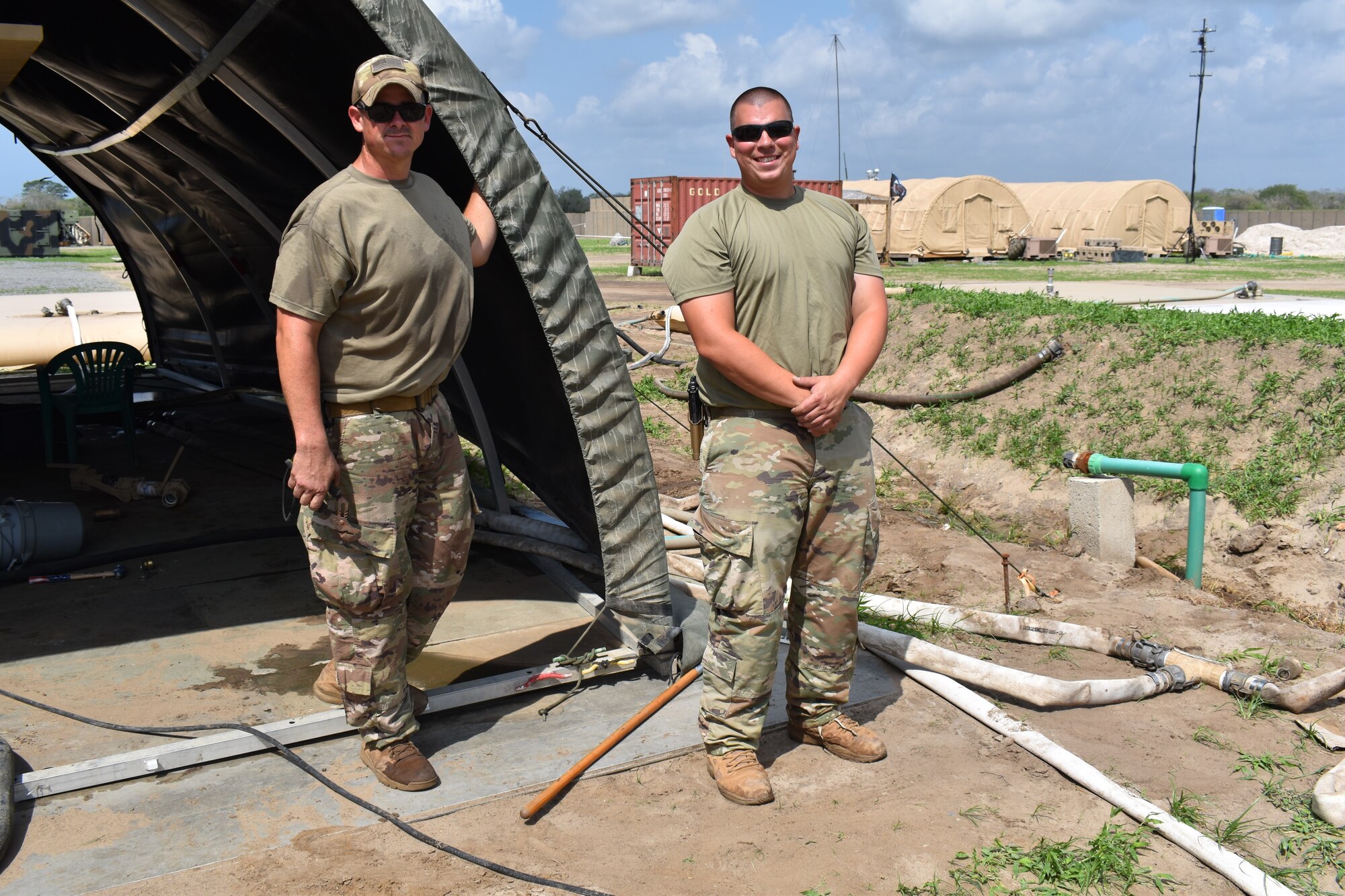 Tech. Sgts Jerl Dunn and Brendan Muchow, water and fuels system maintenance craftsmen for the 776th Expeditionary Air Base Squadron stand in front of their working area at Camp Simba at Manda Bay, May 19, 2021. Some of the responsibilities for Dunn and Muchow were to ensure that the waste and water systems at Camp Simba were in order and up to date alongside with the 475th Expeditionary Air Base Squadron civil engineers. (U.S. Air Force photo by Airman 1st Class Jan K. Valle)