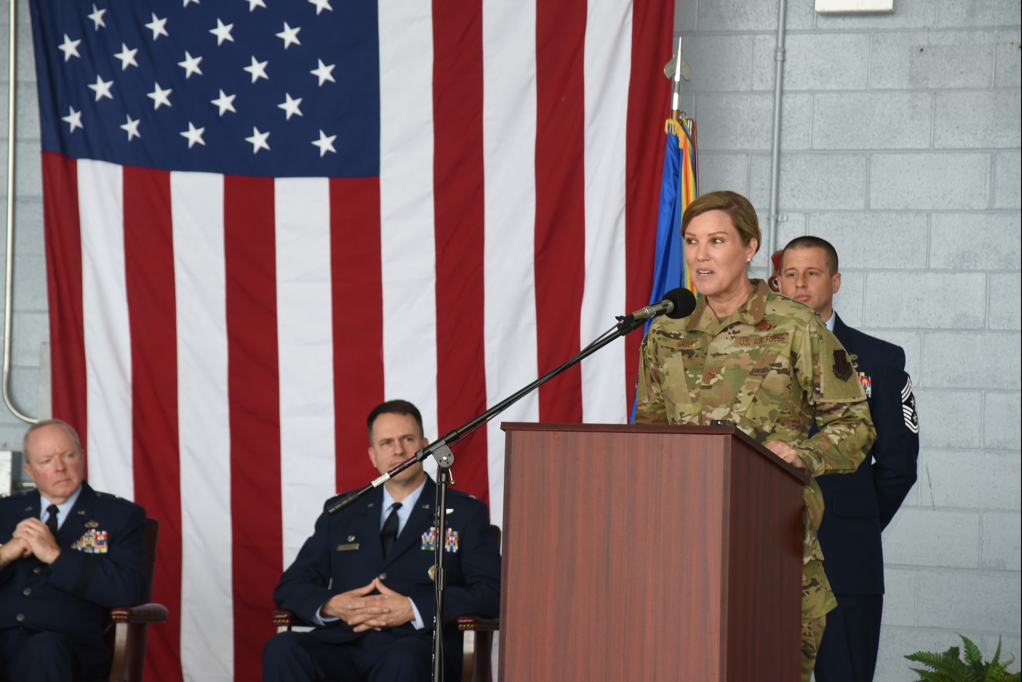 A woman in an air force uniform speaks at a podium.