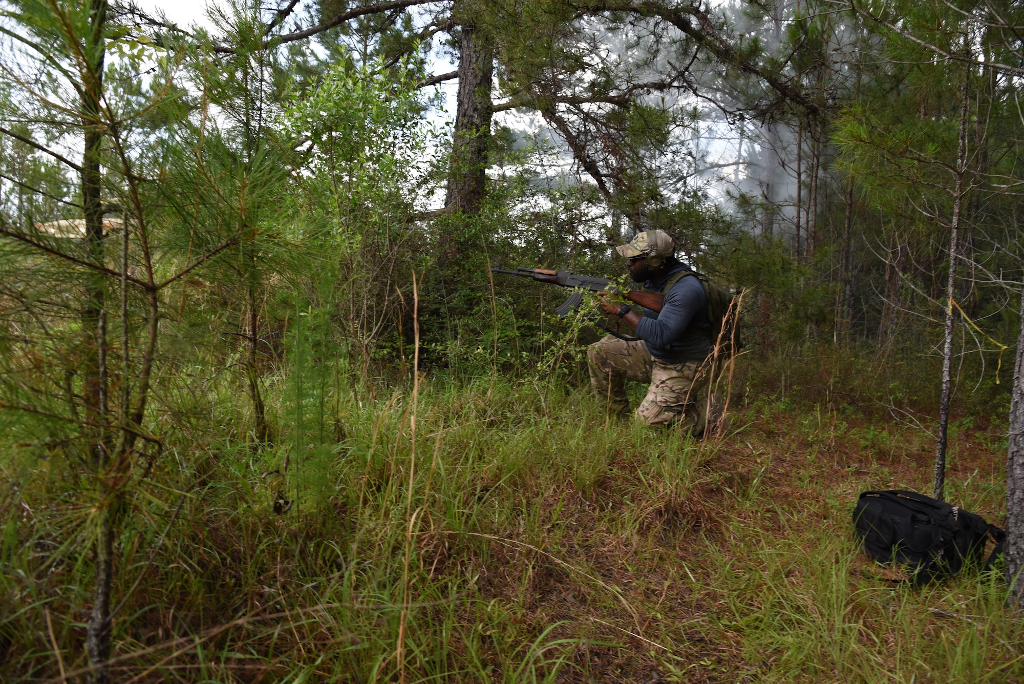 Tech. Sgt. Tommilleus Harper, 403rd Security Forces Squadron squad leader, 'attacked' the convoy using a simulated AK-47 for the small arms attack portion of the mounted lane training route ambush. He was one of four volunteers from the 403rd SFS to go to Camp Shelby Joint Forces Training Center, Hattiesburg, Miss. and help the Asymmetric Threat Training Support Program instructors this week during their annual tour, June 7-11, 2021. This training provides realistic, intense, stressful and challenging battlefield training scenarios for all service members, to include Reserve Officers' Training Corps. (U.S. Air Force photo by Jessica L. Kendziorek)