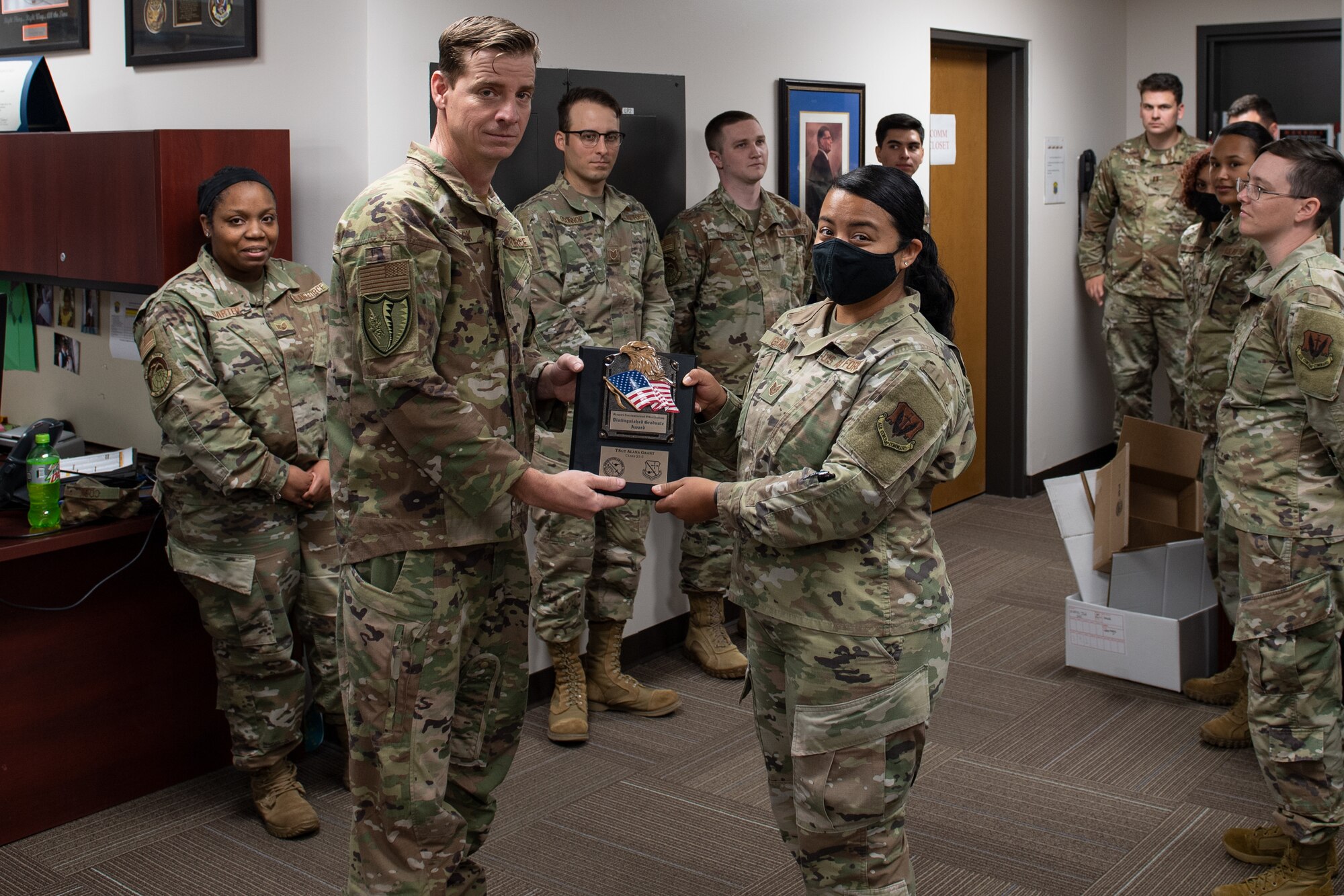 Two service members holding an award
