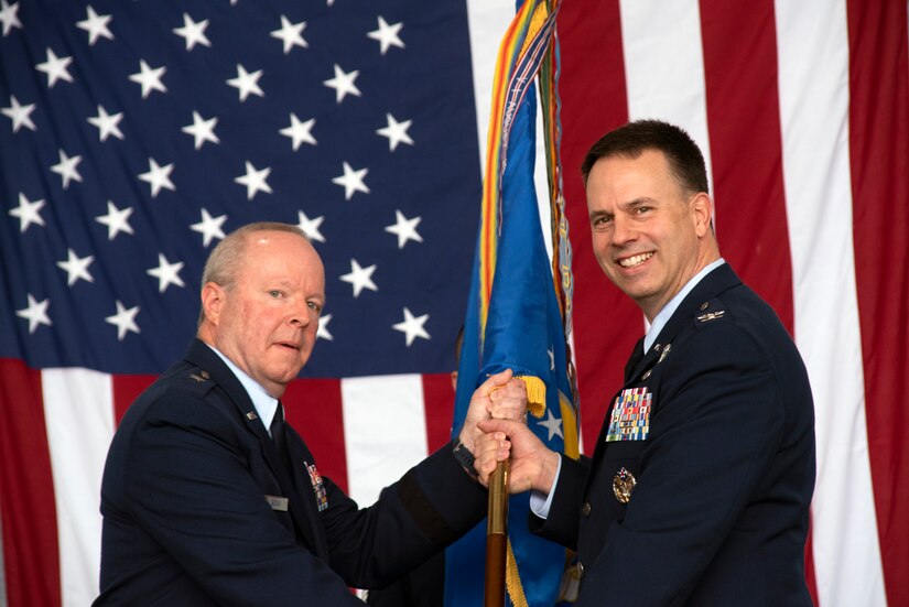 Brig. Gen. Michael Regan, commander of the Pennsylvania Air National Guard, passes the unit colors to 111th Attack Wing Commander Col. Deane E. Thomey, during an assumption of command ceremony here June 13, 2021. Regan, presided over the ceremony recognizing Thomey, who officially assumed command of the 111th when he arrived here from the Pentagon in April.