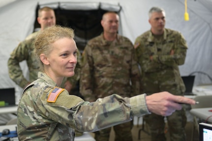 Indiana National Guard Lt. Col. Harmonie Foster, the 38th Infantry Division's logistics officer, points to stats on a screen as other Soldiers look on at the division's tactical operations center at Camp Atterbury, Indiana, June 10, 2021. The division's Soldiers tested virtual battlefield scenarios in Warfighter Exercise 21-5.