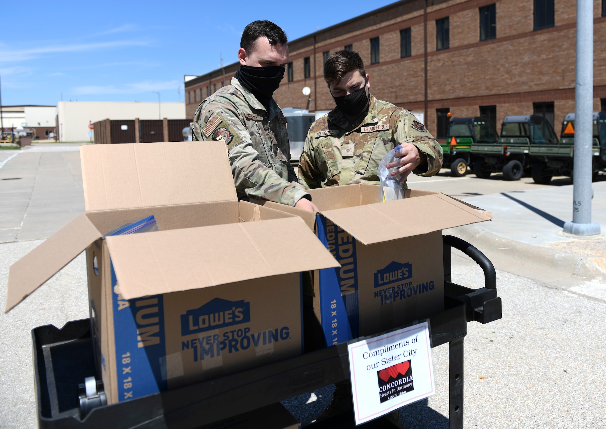 Two 509th Aircraft Maintenance Squadron Airmen grab snack packs at Whiteman Air Force Base, Missouri, May 5, 2021. The 509th AMXS Whiteman Base Community Council Concordia, Missouri, liaison delivered the snacks to support the Airmen through an exercise. (U.S. Air Force photo by Staff Sgt. Sadie Colbert)