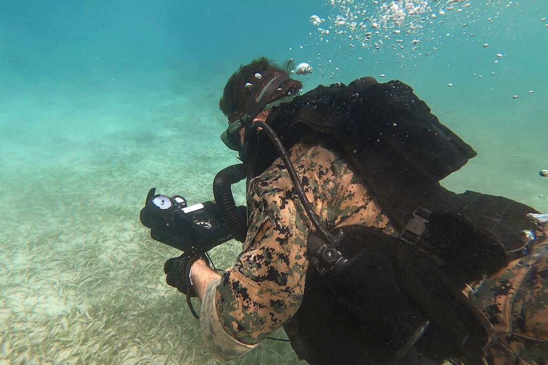 A Marine swims underwater.
