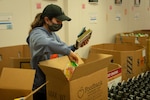 Navy Petty Officer 3rd Class Irely Garcia, assigned to the aircraft carrier USS John C. Stennis (CVN 74), puts donated food items into boxes at the Foodbank of Southeastern Virginia and the Eastern Shore, in Norfolk, Va., April 1, 2021. As part of President Joe Biden’s strategy to stop the spread of COVID-19, Defense Logistics Agency Troop Support provided more than 400,000 adult and youth face masks to 16 local community centers, including foodbanks, in Philadelphia in May.