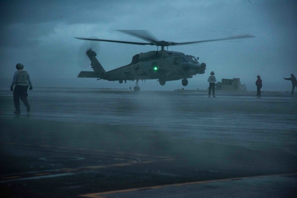 An MH-60R Sea Hawk attached to the "Saberhawks" of Helicopter Maritime Strike Squadron (HSM) 77 lands on the flight deck of the U.S. Navy's only forward-deployed aircraft carrier USS Ronald Reagan (CVN 76).