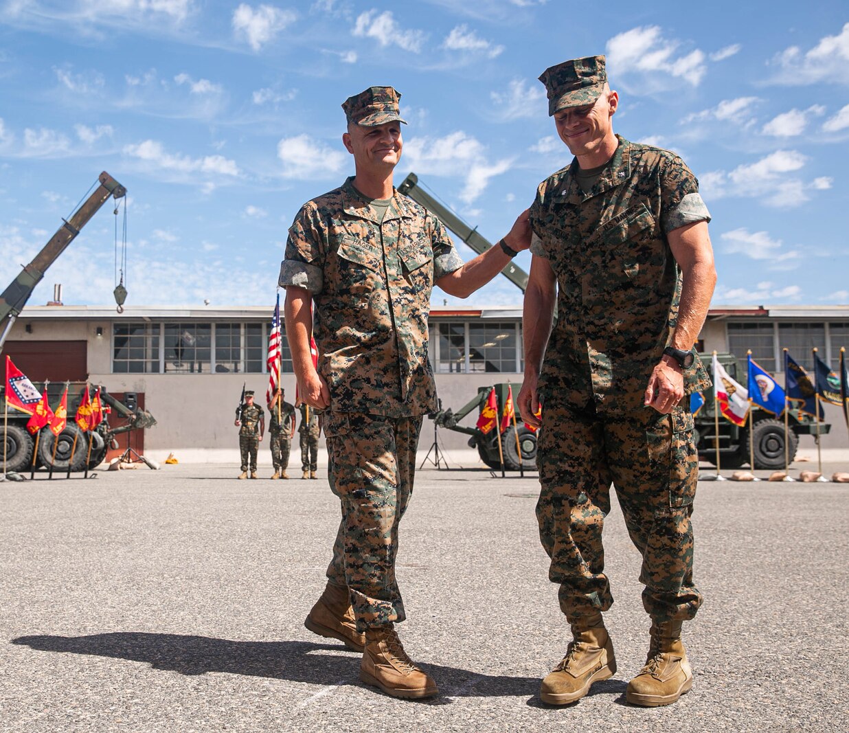 U.S. Marine Corps Lt. Col. Matt Hager, outgoing commanding officer, left, 1st Maintenance Battalion, and incoming commanding officer Lt. Col. Joseph R. Petkus, right, embrace after exchanging the Battalion colors.
