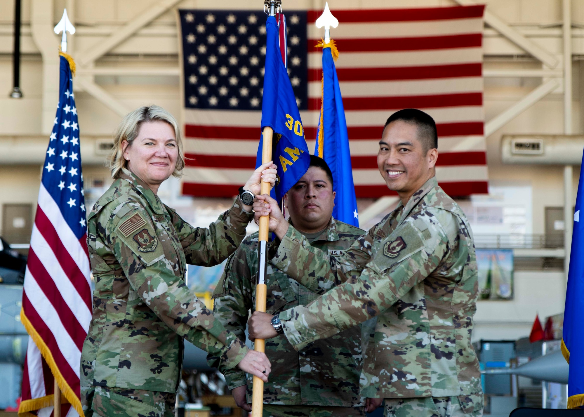 Two Airmen pass the guidon during a change of command ceremony.