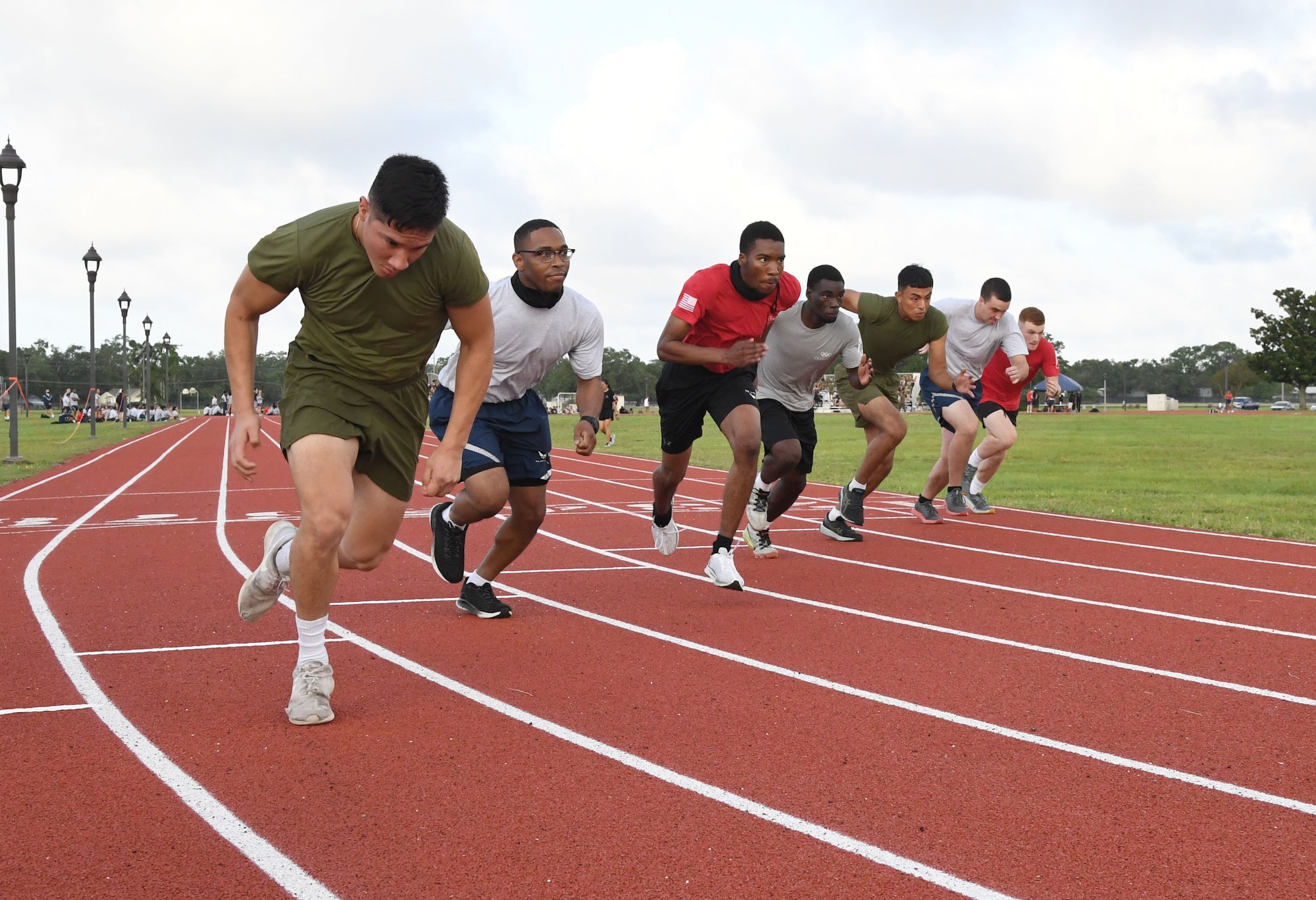 U.S. Airmen and Marines in the 81st Training Group participates in the 200 meter run during the 81st Training Group Olympics at Keesler Air Force Base, Mississippi, June 11, 2021. The event also included competitions in weight lifting, long jump, shot put and discus. (U.S. Air Force photo by Kemberly Groue)
