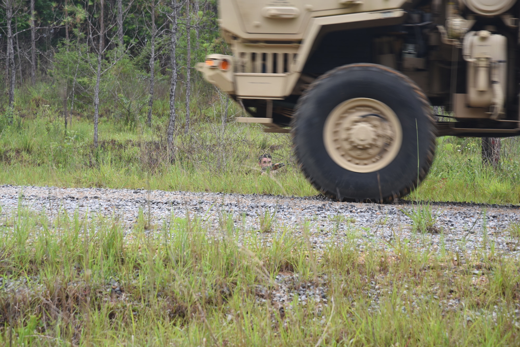 Tech. Sgt. Brandon Breaux, 403rd Security Forces Squadron squad leader, 'attacked' the convoy using a simulated AK-47 for the small arms attack portion of the mounted lane training route ambush. He was one of four volunteers from the 403rd SFS to go to Camp Shelby Joint Forces Training Center, Hattiesburg, Miss. and help the Asymmetric Threat Training Support Program instructors this week during their annual tour, June 7-11, 2021. This training provides realistic, intense, stressful and challenging battlefield training scenarios for all service members, to include Reserve Officers' Training Corps. (U.S. Air Force photo by Jessica L. Kendziorek)