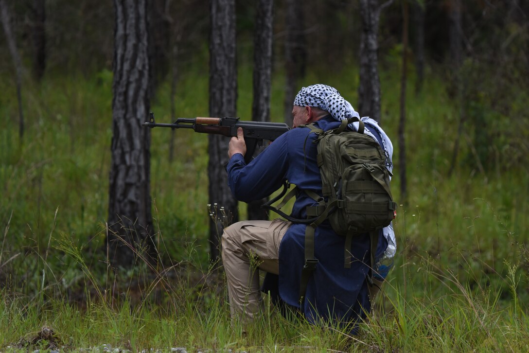 Senior Airman Matthew Danyus, 403rd Security Forces Squadron squad member, 'attacked' the convoy using a simulated AK-47 for the small arms attack portion of the mounted lane training route ambush. He was one of four volunteers from the 403rd SFS to go to Camp Shelby Joint Forces Training Center, Hattiesburg, Miss. and help the Asymmetric Threat Training Support Program instructors this week during their annual tour, June 7-11, 2021. This training provides realistic, intense, stressful and challenging battlefield training scenarios for all service members, to include Reserve Officers' Training Corps. (U.S. Air Force photo by Jessica L. Kendziorek)