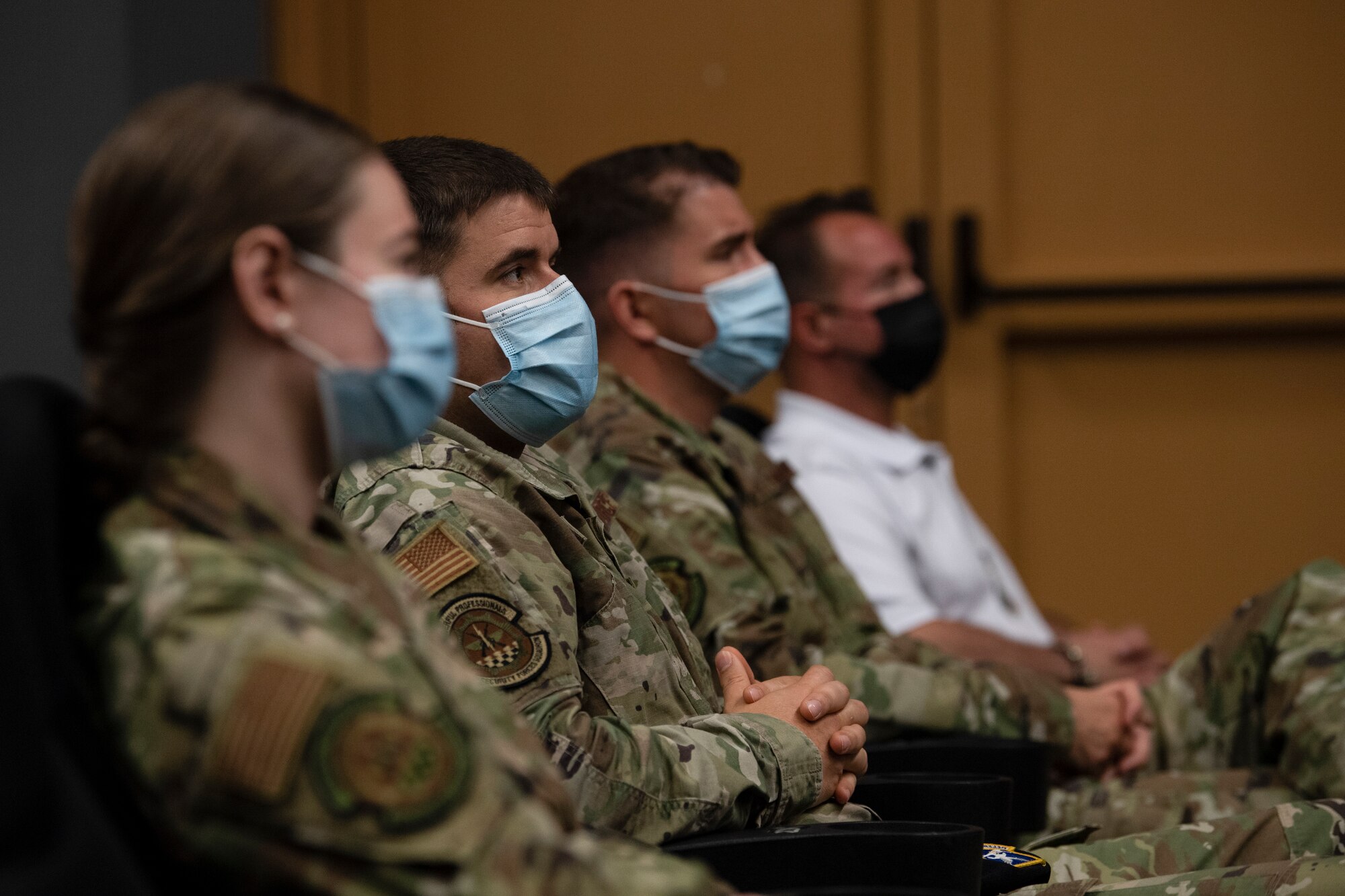 U.S. Air Force Airmen watch a military working dog retirement ceremony.