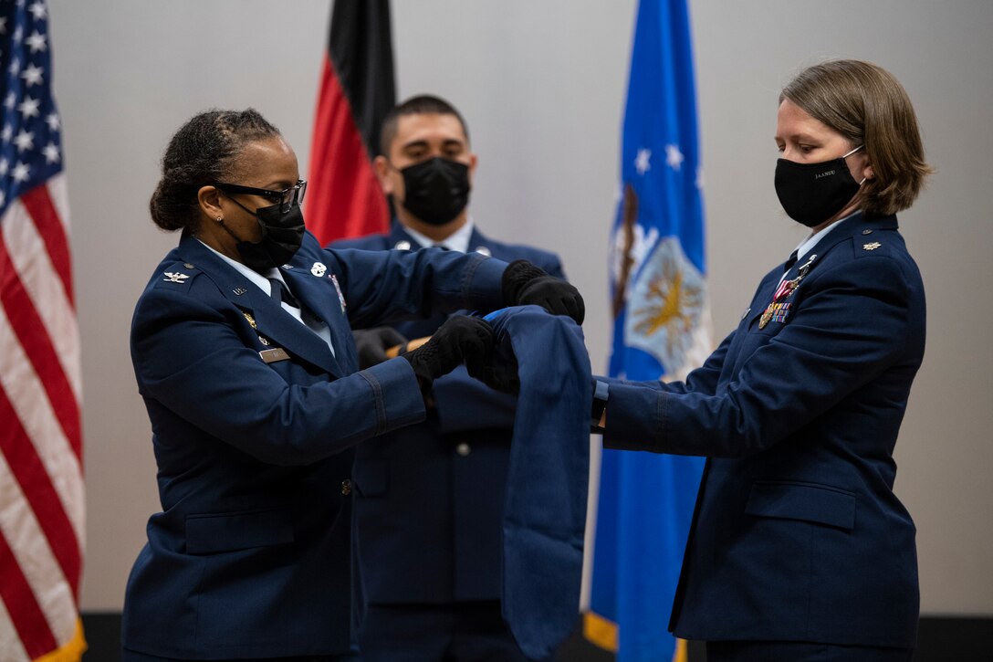 52nd Medical Group commander and former 52nd Dental Squadron commander cover the 52nd DS guidon.